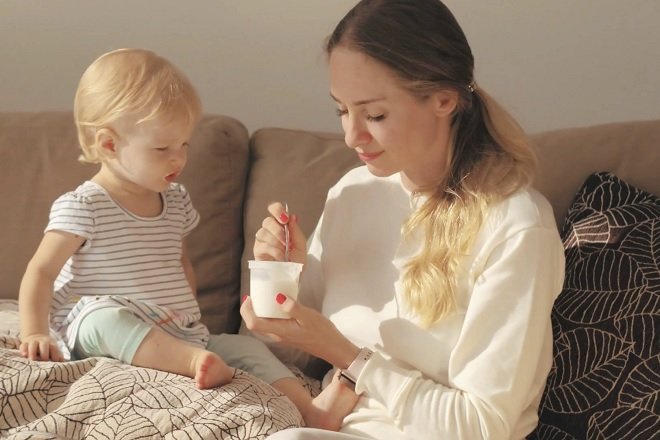 mẹ cho con gái ăn sữa chua trên ghế sofa