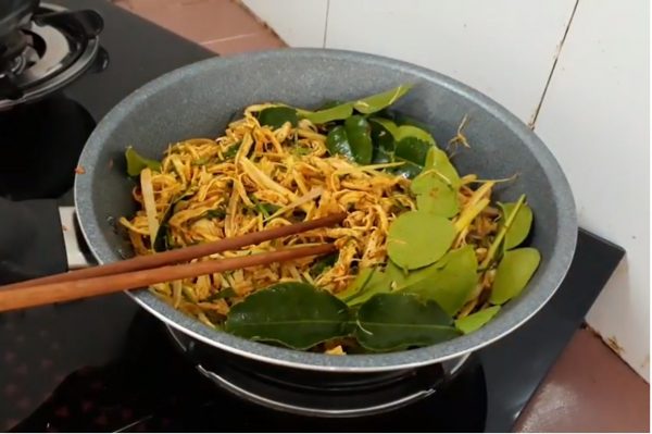 Sau cùng bạn bỏ lá chúc hoặc lá giang vào chảo