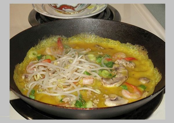 Cho đầy đủ tôm, thịt, giá lên trên mặt bánh