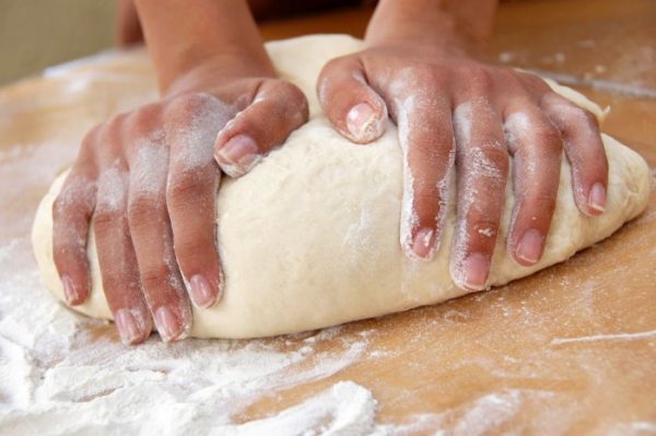 Dung cả bàn tay ấn mạnh vào bột để nhào bột mịn