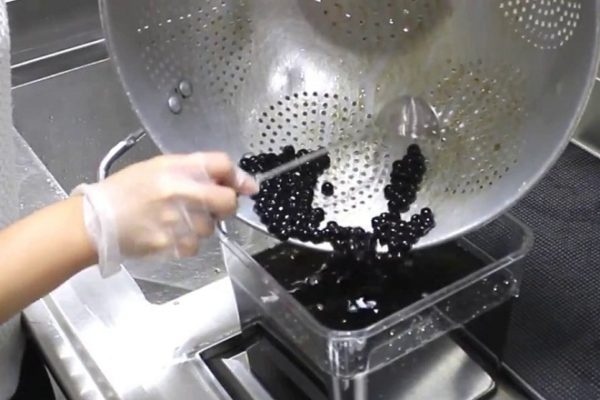 đổ thạch trân châu đen vào hộp nhựa bảo quản