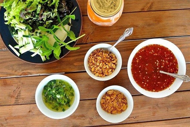 dùng bún thịt nướng với nước mắm đi kèm mỡ hành, đậu phộng và rau dưa
