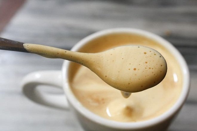 muỗng bọt kem múc từ cốc cafe trứng