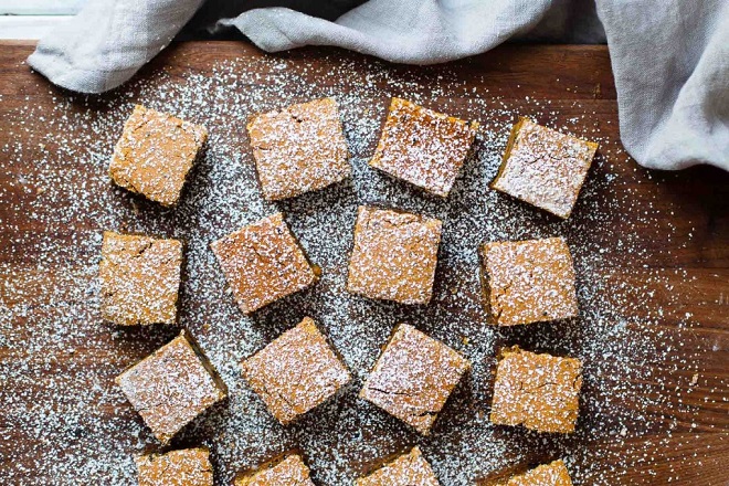 rắc đường bột lên bánh mochi bí đỏ mè đen cắt khối vuông